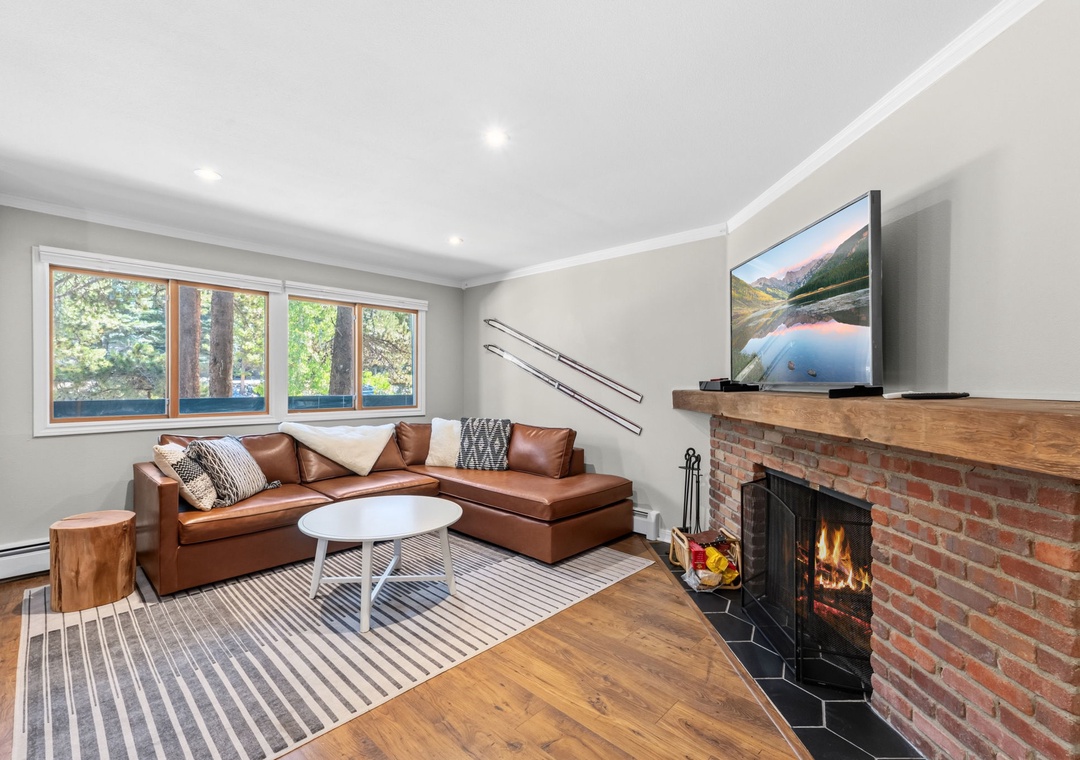 Sink into the leather sectional and warm your toes by the crackling fireplace as natural light pours through the windows, creating the perfect retreat for cozy evenings.