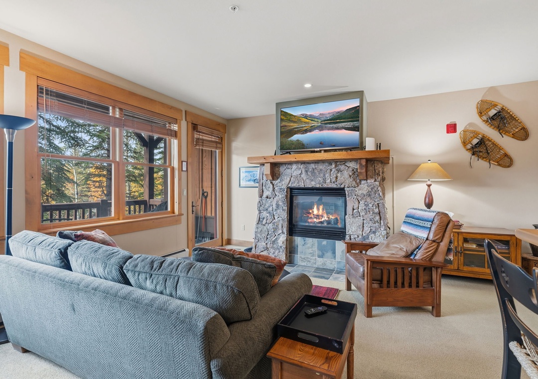 Cozy up in your inviting living room, where natural wood and a crackling stone fireplace welcome you home after mountain adventures.