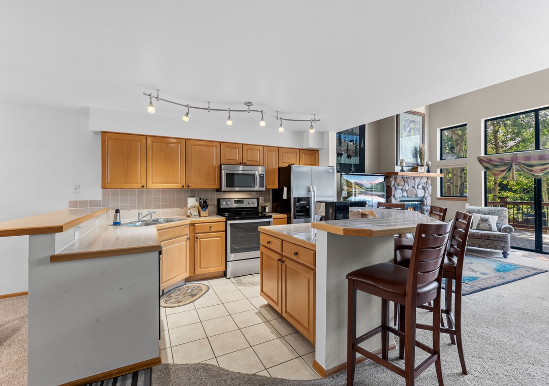 Your open-concept space blends the kitchen and living area seamlessly, where you'll whip up meals at warm wood counters while staying connected to your guests lounging by the windows.