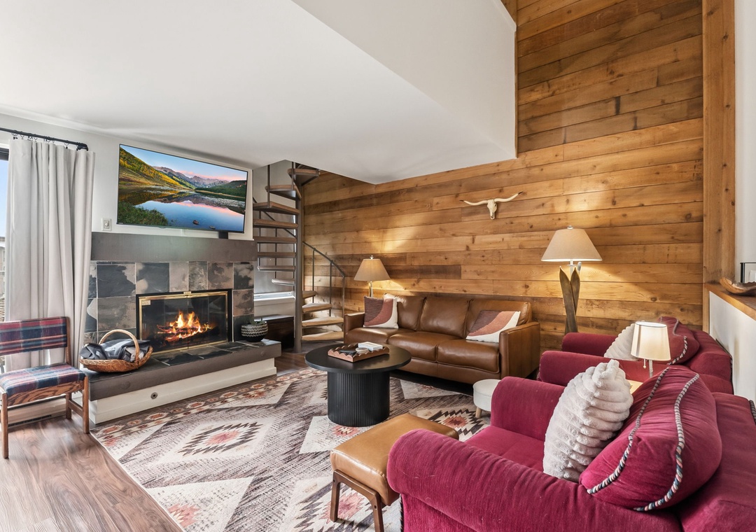 Cozy up by the crackling fireplace in your mountain retreat with rustic wood walls and plush seating for ultimate relaxation.