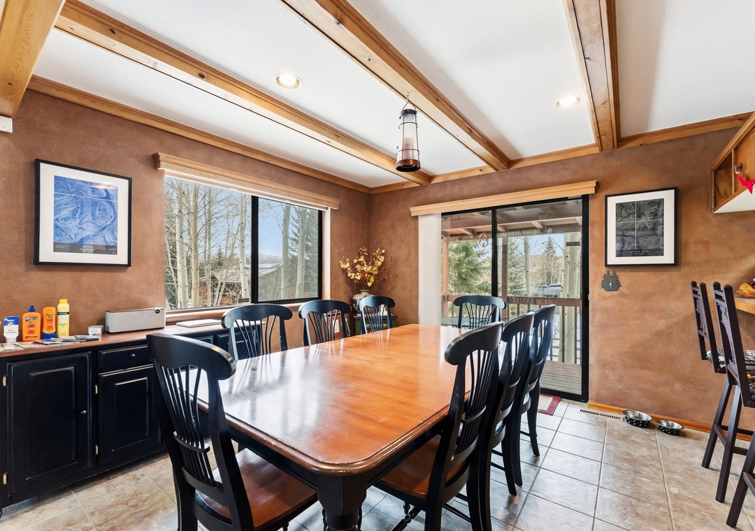 Gather around this inviting dining table where warm wood beams and rustic charm create the perfect setting for memorable meals together.