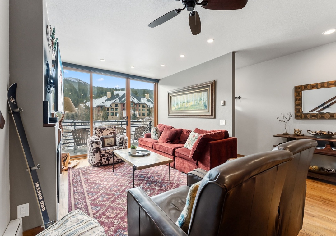 Relax in your cozy living room with plush seating and stunning mountain views through floor-to-ceiling windows.