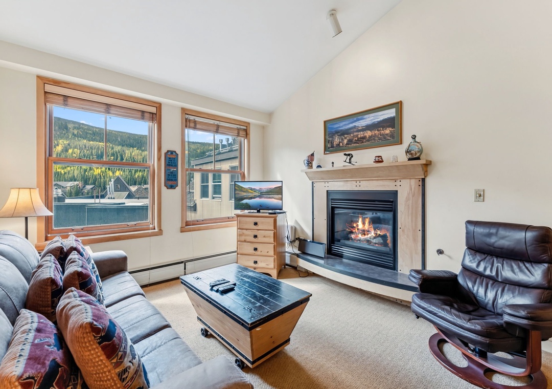 Curl up in your cozy living room, where a crackling fireplace and mountain views create the perfect retreat after a day of adventure.