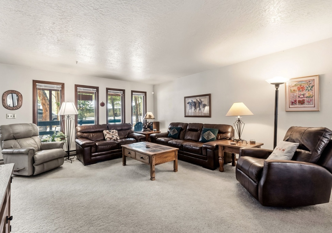 Sink into plush leather recliners in your spacious living room, where warm lighting and mountain views create the perfect retreat.
