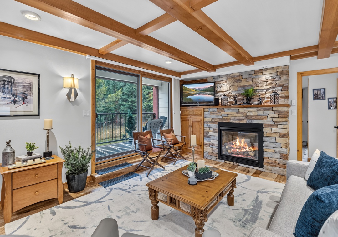 Unwind in your spacious living room, where exposed beam ceilings and a glowing stone fireplace create a cozy mountain retreat. Step outside to your private deck for fresh air and peaceful moments surrounded by nature.