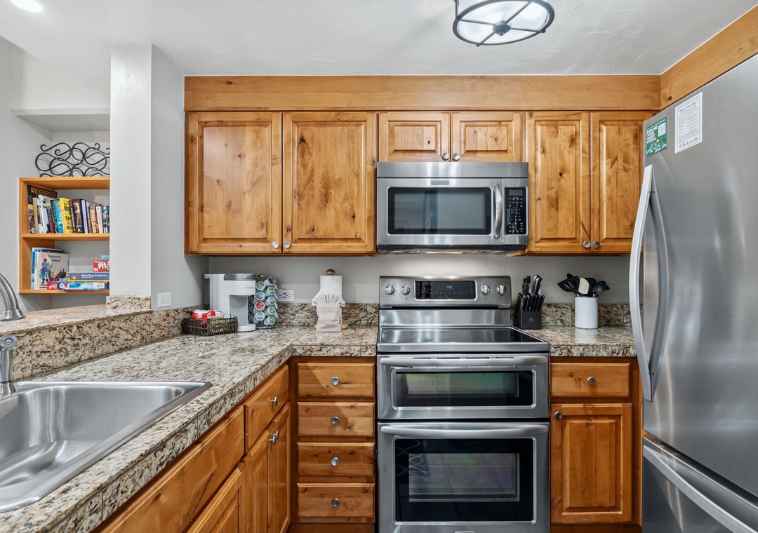 Your fully equipped kitchen features granite countertops, stainless steel appliances, and warm wood cabinetry—perfect for preparing home-cooked meals during your stay.