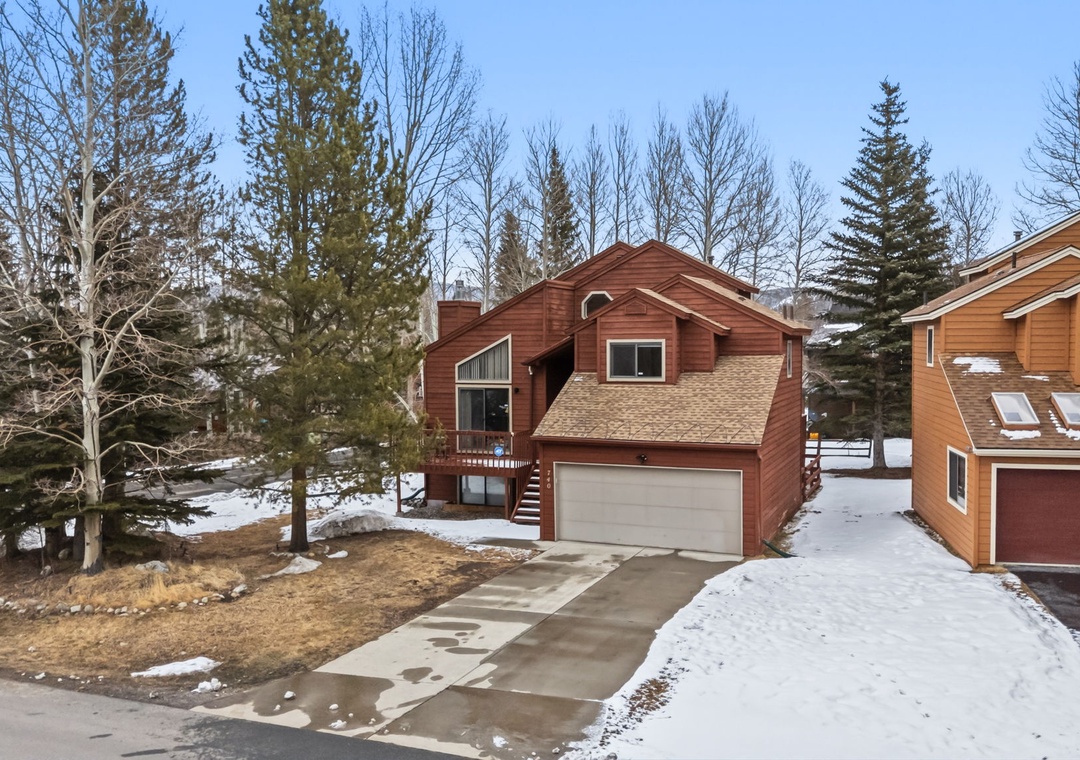 Cozy mountain cabin nestled among towering evergreens with convenient parking and winter charm in a peaceful wooded neighborhood.