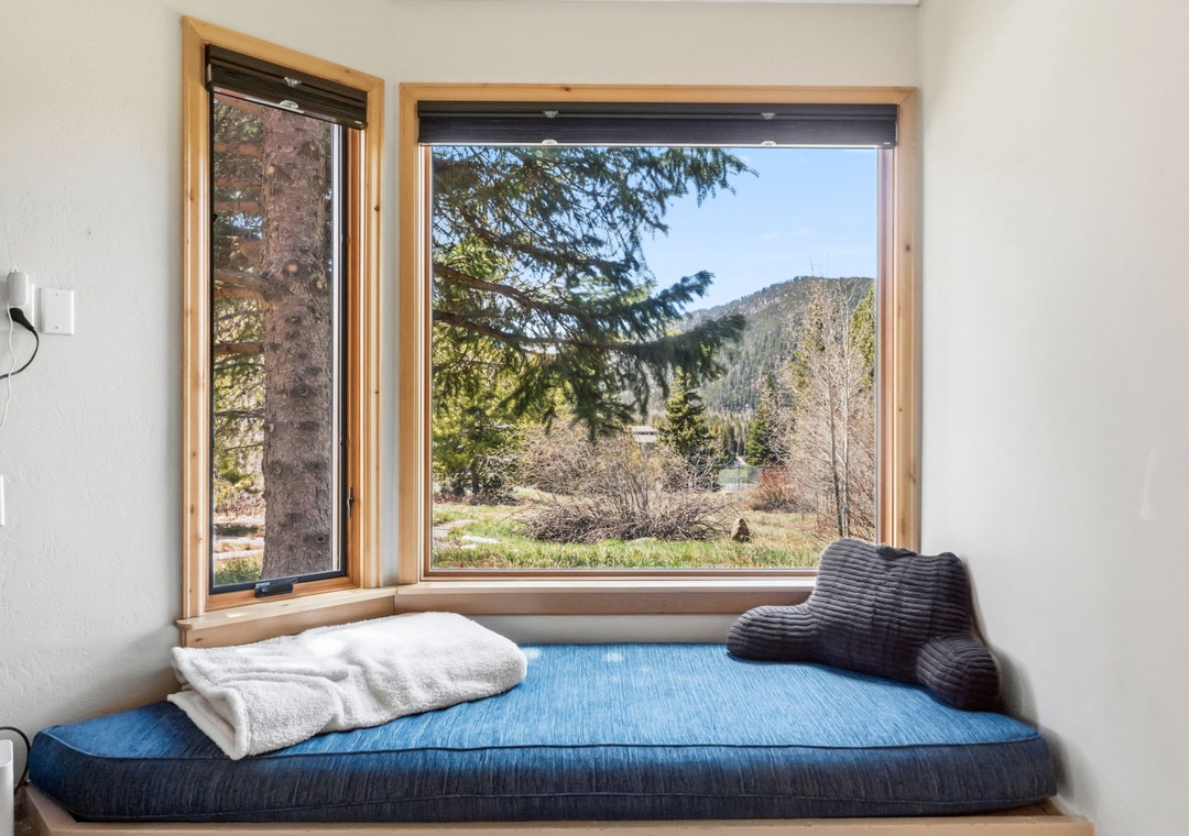 Curl up in your cozy window nook with mountain and forest views stretching before you—the perfect spot to unwind with a book or morning coffee.