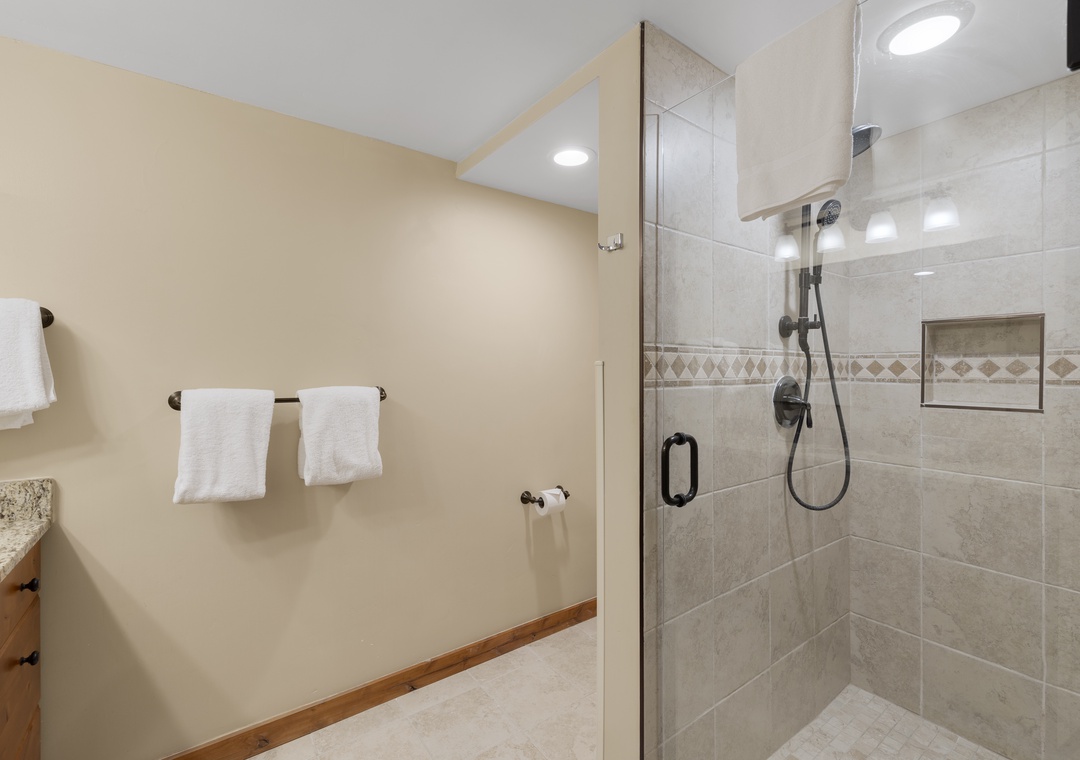 Step into your spacious bathroom where fresh towels await and a luxurious walk-in shower invites you to unwind after exploring.