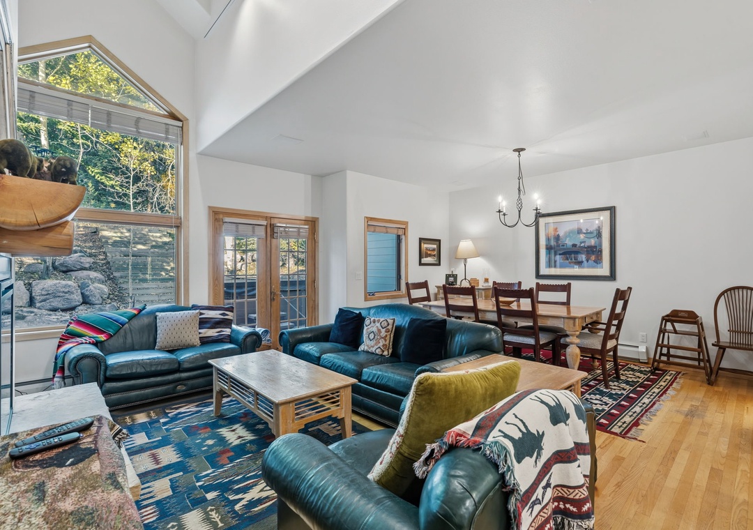 Sink into plush leather seating and gaze through soaring windows at the natural beauty surrounding you. The open layout flows seamlessly from your cozy living space to the dining area, perfect for memorable gatherings.