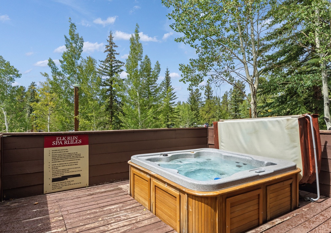 Soak away your cares in this private hot tub, surrounded by towering evergreens and aspen trees under a bright mountain sky.