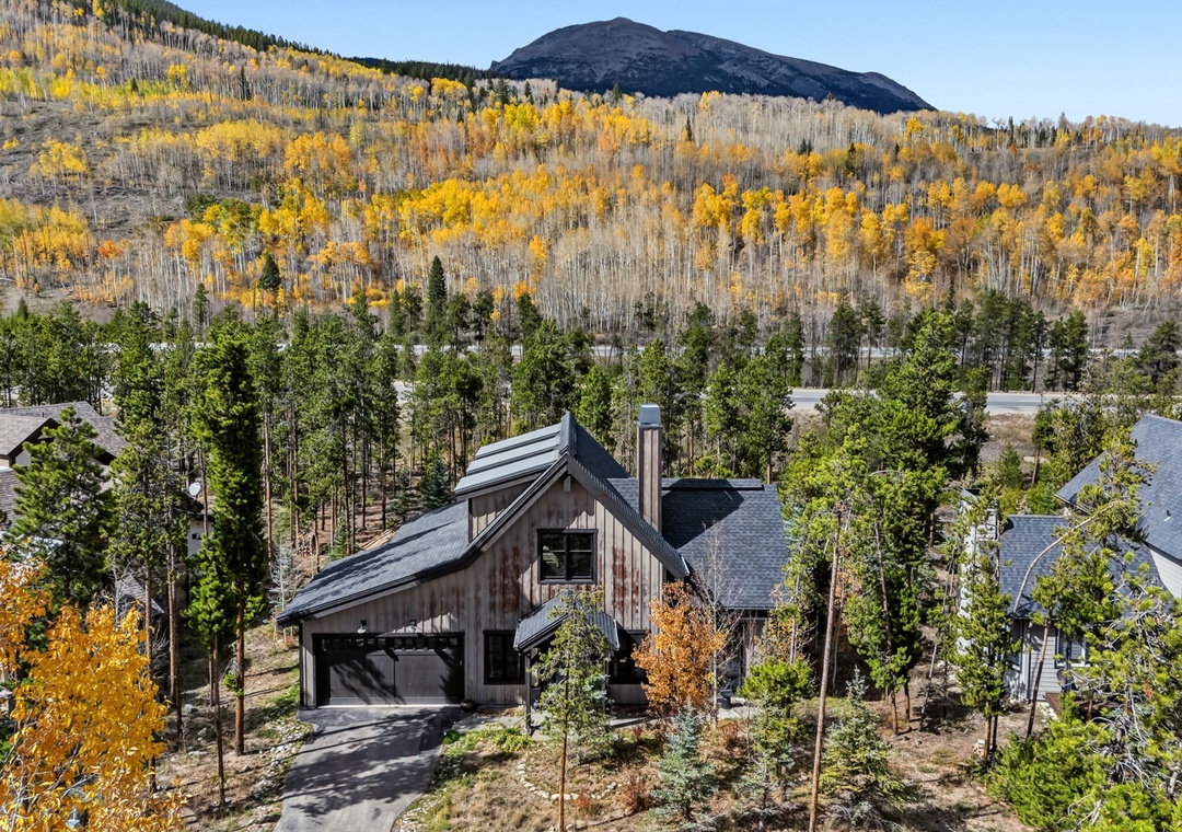 This stunning mountain retreat is nestled among aspens and evergreens with dramatic peaks rising beyond.