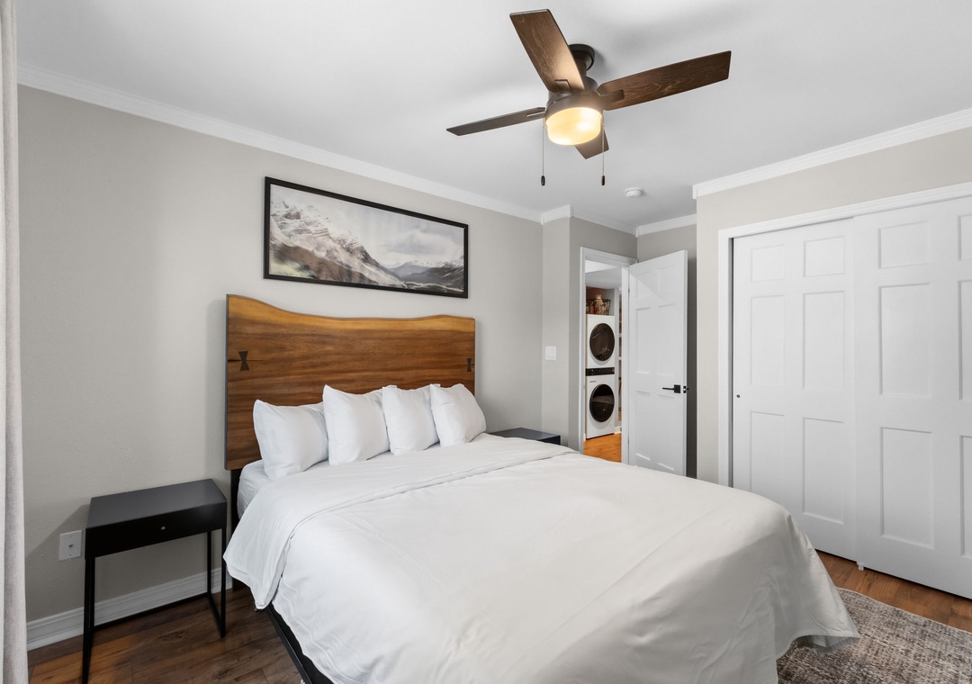 Settle into crisp, hotel-quality linens beneath a warm ceiling fan. Your cozy bedroom includes mountain-inspired touches, a sleek nightstand, and convenient in-unit laundry just steps from your bed.