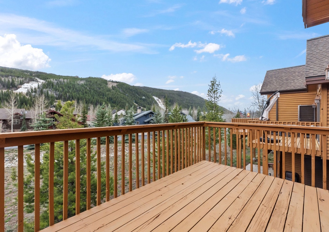 Spacious wooden deck with stunning mountain views where you can sip morning coffee while taking in the peaceful alpine scenery.
