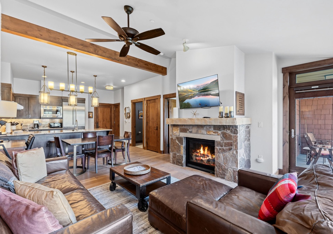 Gather around your stone fireplace in this open-concept mountain retreat. The spacious living area flows into a dining space and fully-equipped kitchen, complete with exposed beams overhead and a cozy balcony just steps away.
