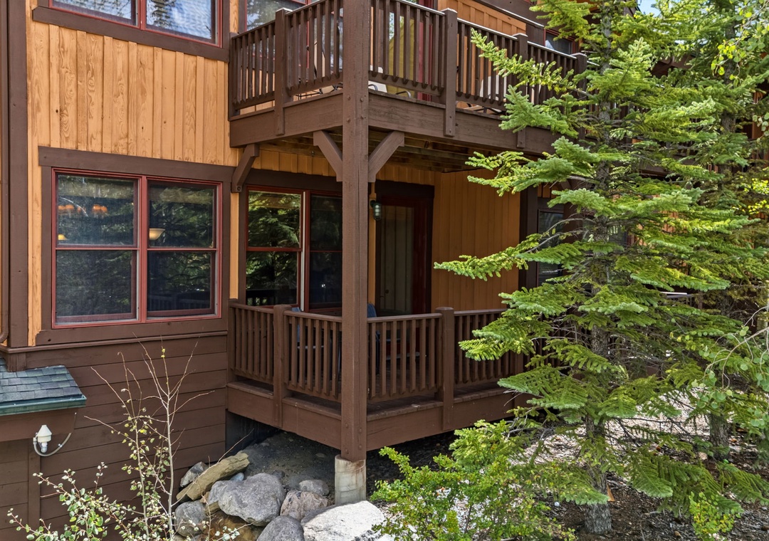 This charming mountain retreat features natural wood siding and two spacious private balconies, nestled among evergreen trees and surrounded by native landscaping for a peaceful, secluded getaway.