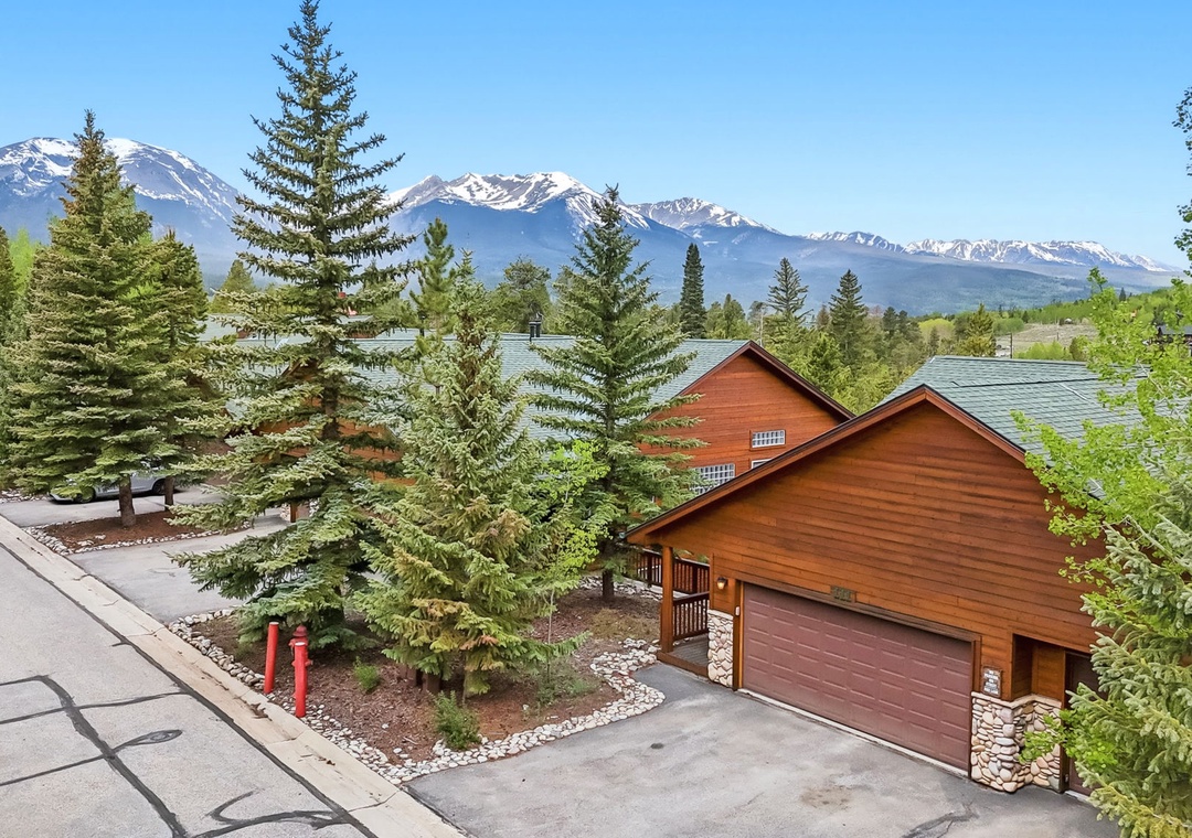 Charming mountain property framed by evergreens and backed by snow-capped peaks, with convenient parking and peaceful neighborhood setting for your stay.