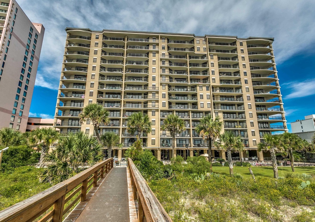 Step onto your private boardwalk leading to this stunning beachfront resort, where swaying palms and ocean breezes welcome you to your coastal retreat.