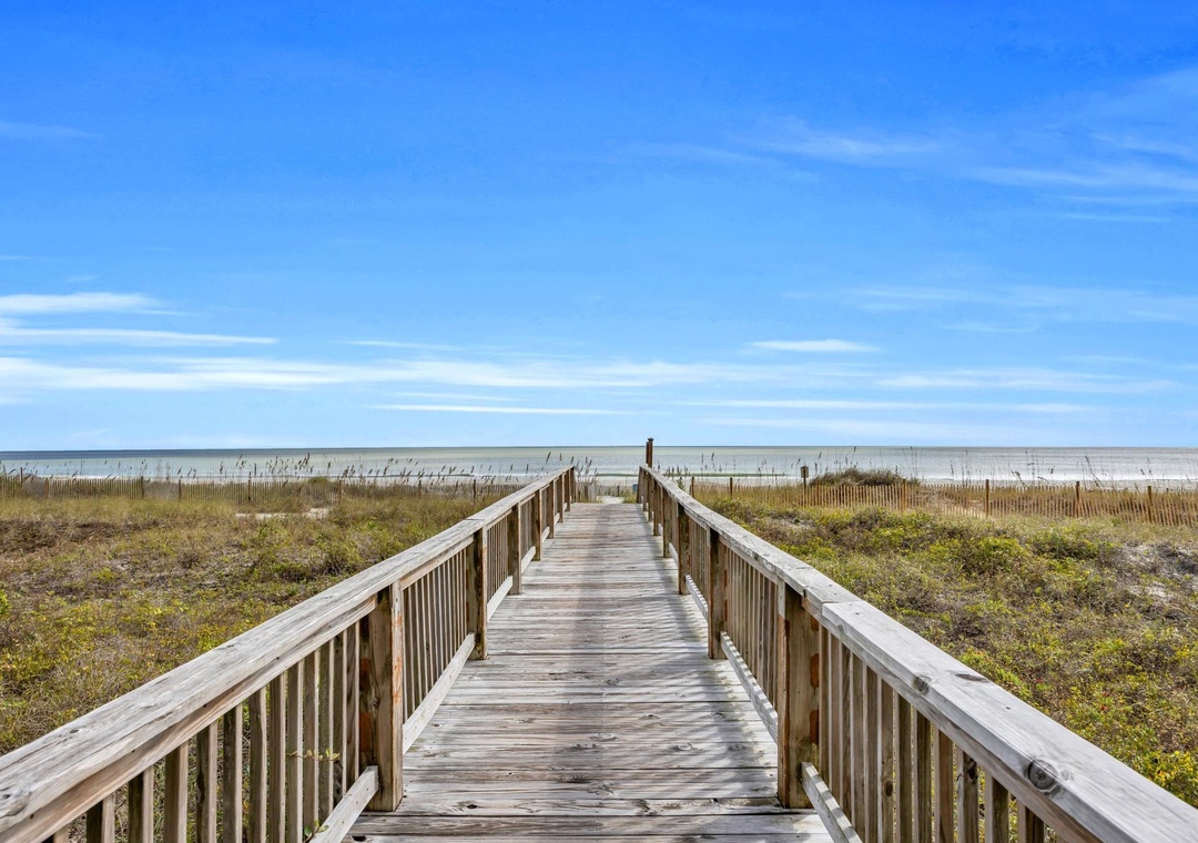 Step onto this charming wooden boardwalk and feel the ocean breeze guide you to pristine sands. Your private pathway to paradise awaits, where endless blue skies meet the shore.