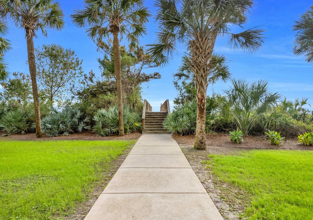 Step into your own tropical paradise where swaying palms frame your path to relaxation. Feel the warm breeze and imagine strolling through this lush garden sanctuary.