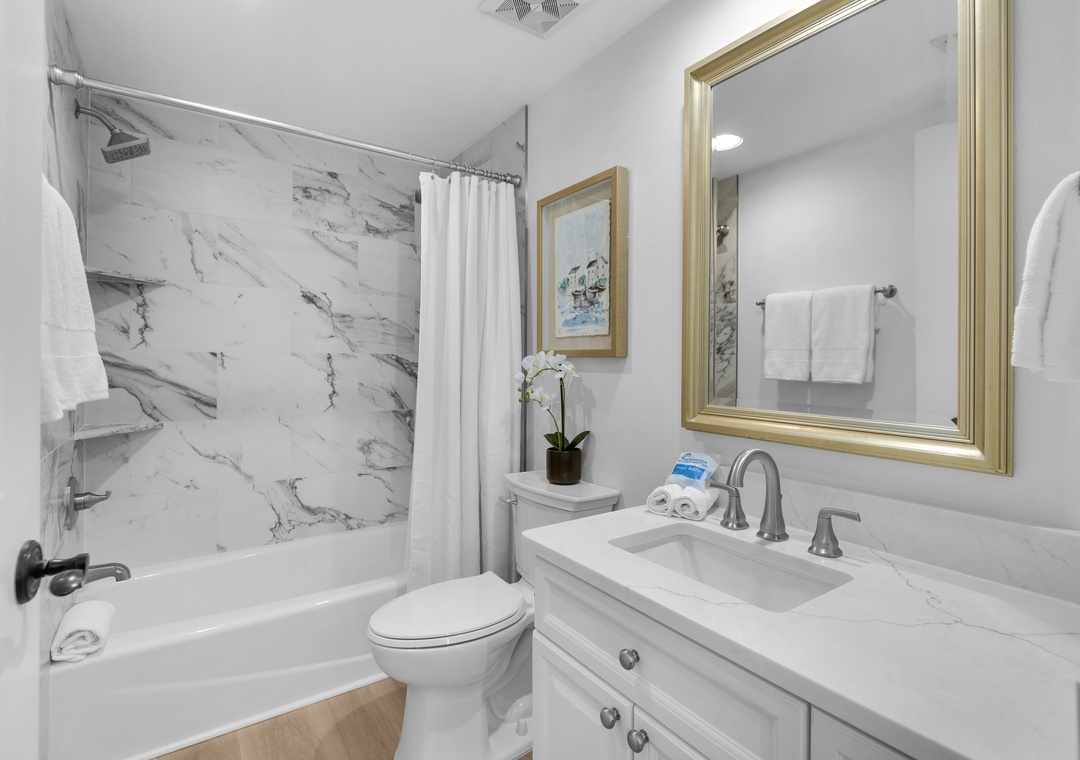 The guest bathroom features a tiled shower/tub combo