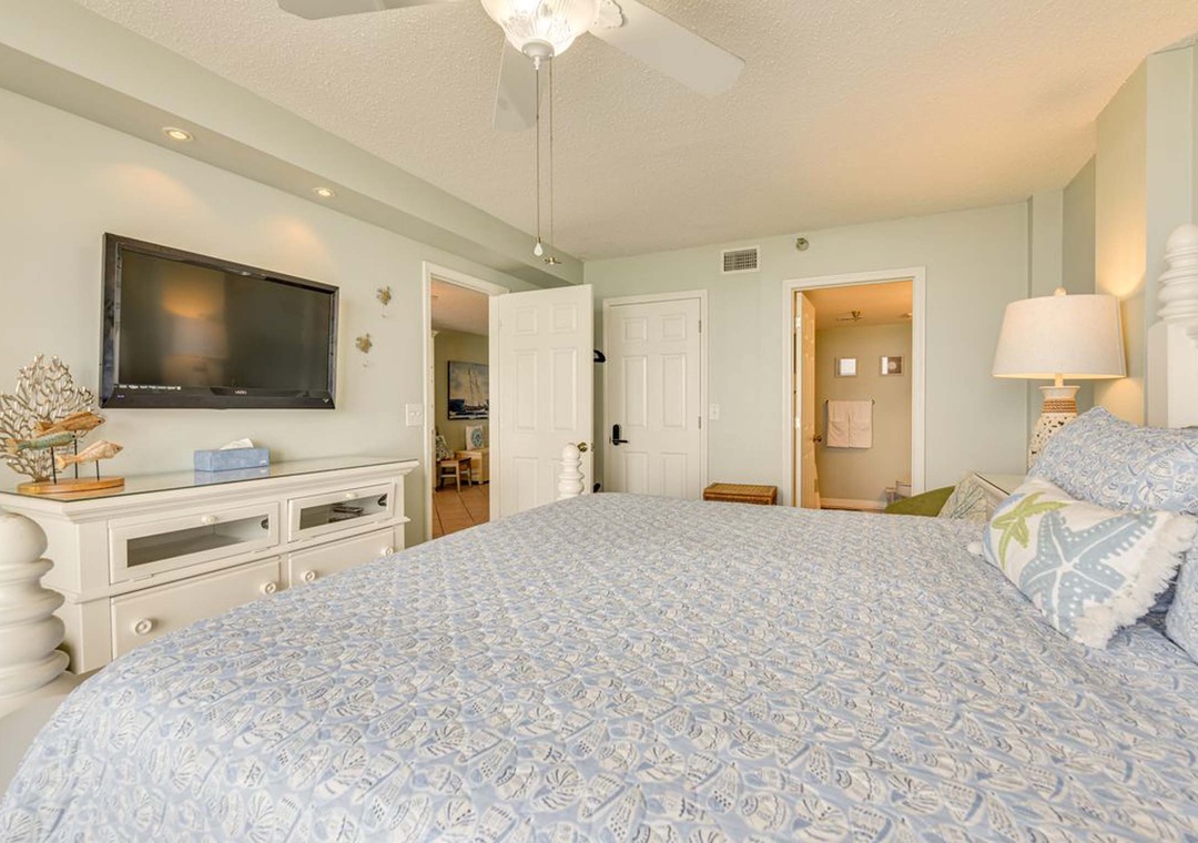 King primary suite with mounted flat-screen TV and ensuite bathroom
