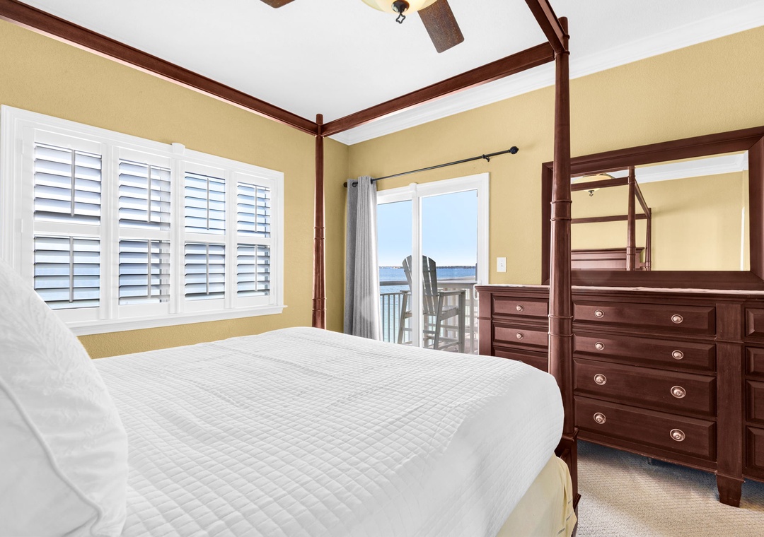 Queen primary bedroom with balcony access