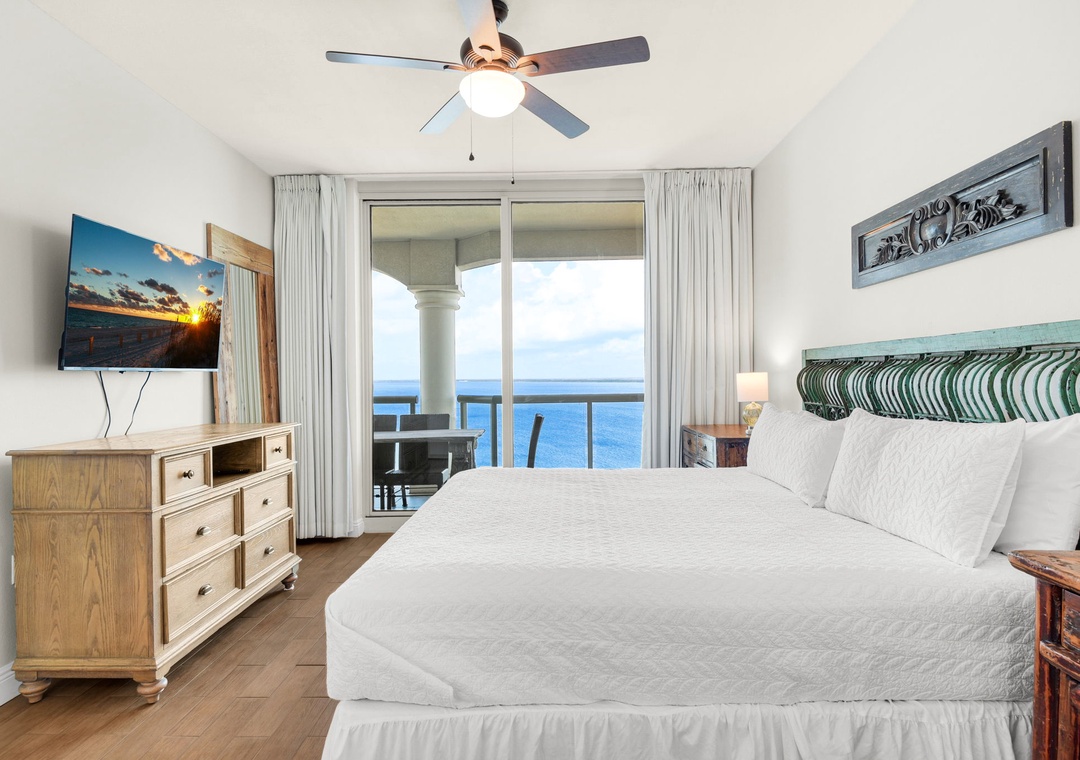 Primary bedroom with king bed and balcony access