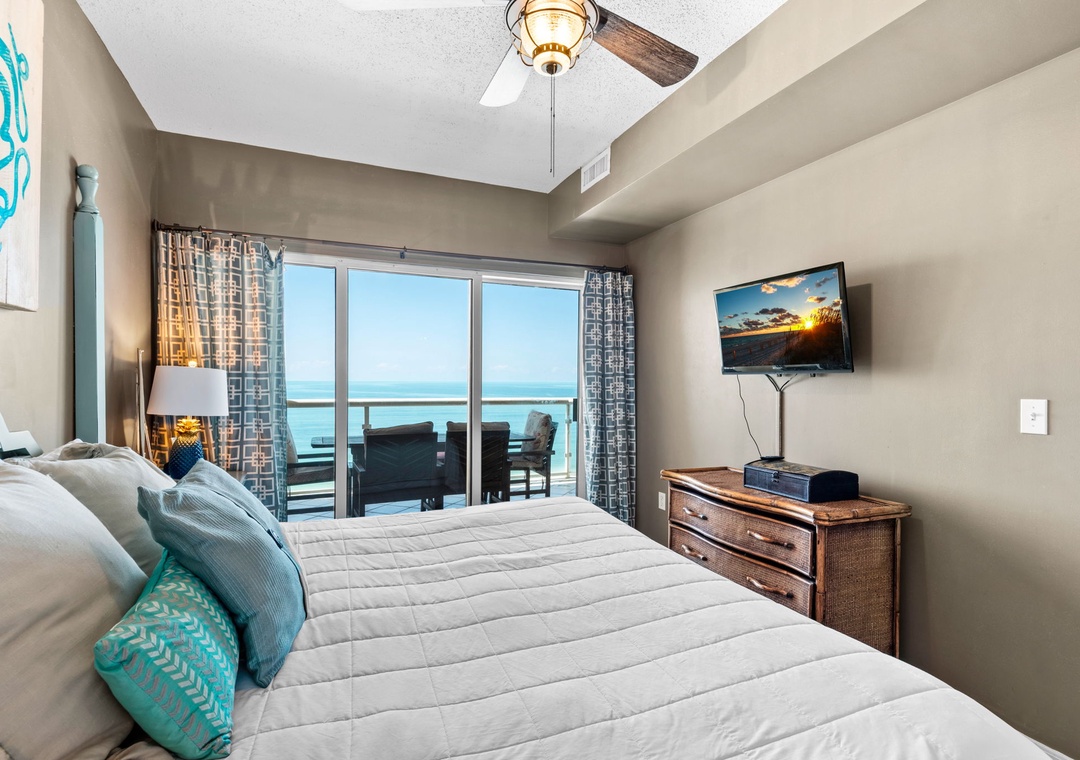 Primary bedroom with king bed and balcony access