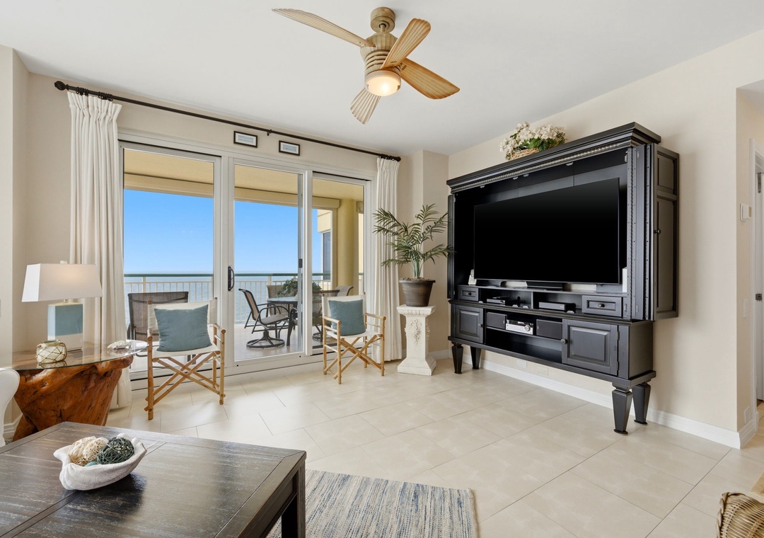 Beach Colony Tower PH1B - Unwind in your bright, spacious living room with coastal décor and a large entertainment center, just steps from your private balcony overlooking stunning sea views.