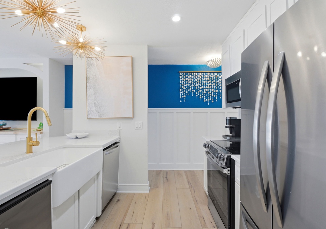 North Lost Key Landing B2- Step into your bright, modern kitchen with gleaming countertops, stainless-steel appliances, and striking gold fixtures that add a touch of warmth to your culinary space.
