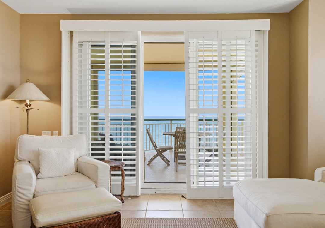 Beach Colony T PH1D- Step through your private balcony doors to feel the ocean breeze and take in stunning sea views from your cozy living space, complete with plush seating and warm natural light.