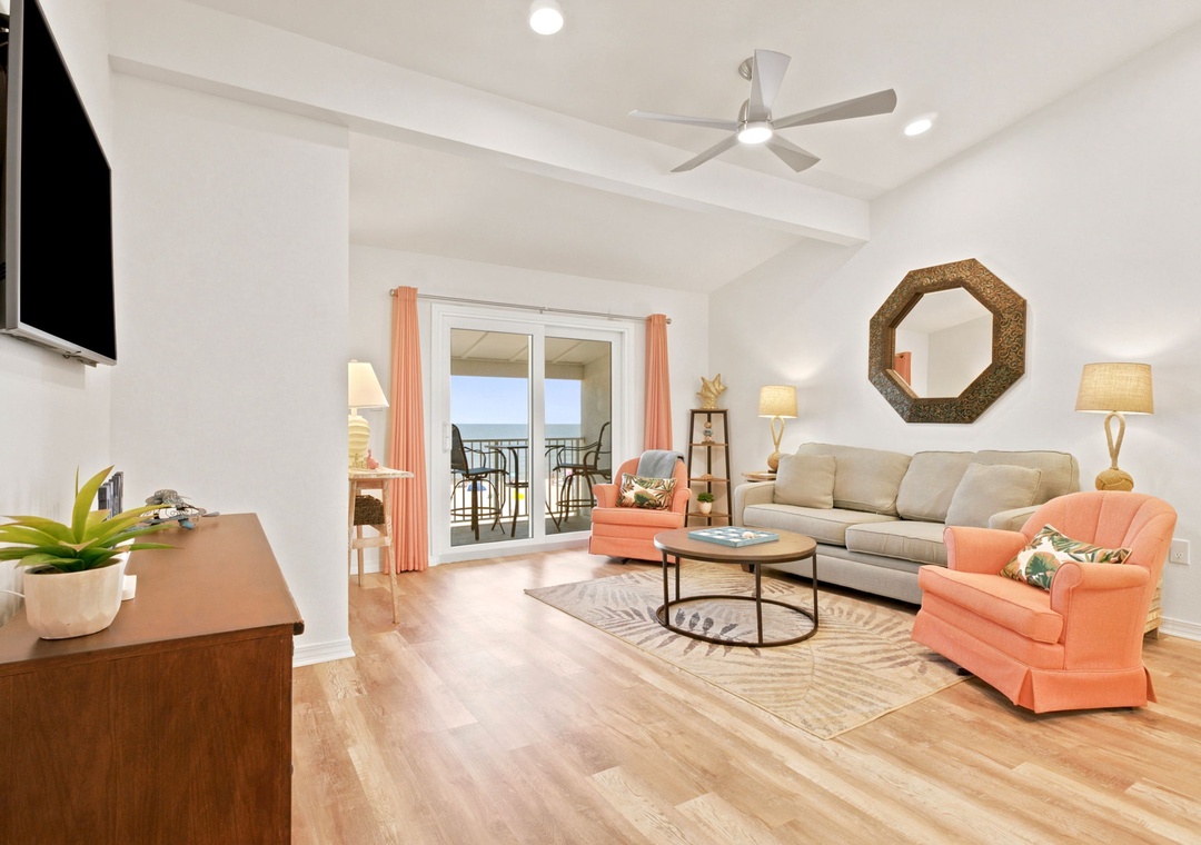 Gulfside Villas 2B- Step into your inviting living room with vaulted ceilings, coastal decor, and balcony access—perfect for unwinding after beach adventures.