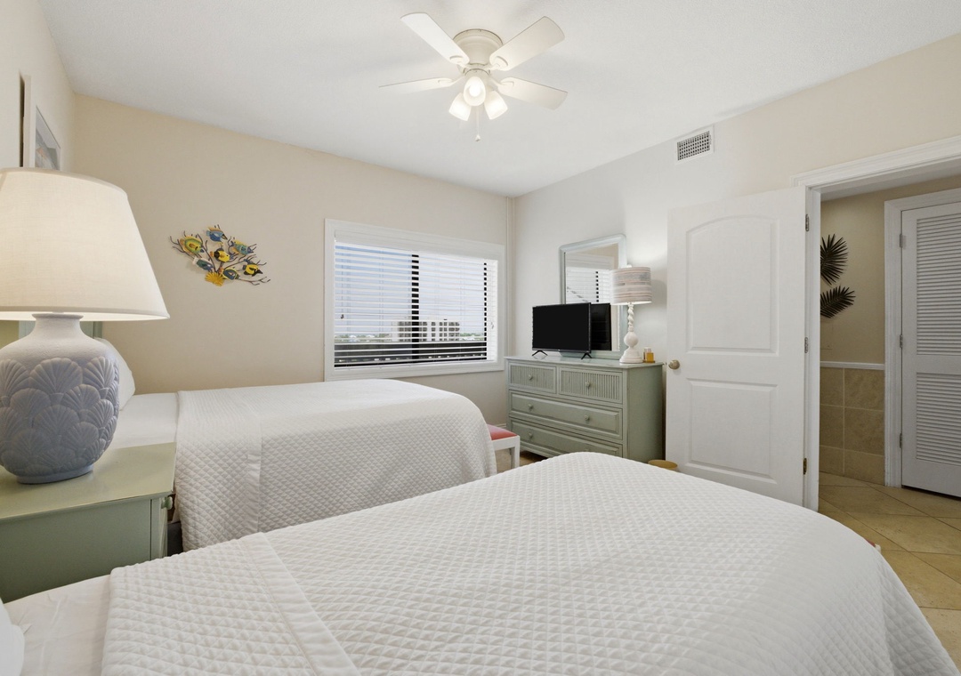 Shipwatch D803- Drift into restful sleep on plush beds with soft linens, cooled by a ceiling fan and natural light streaming through your window.
