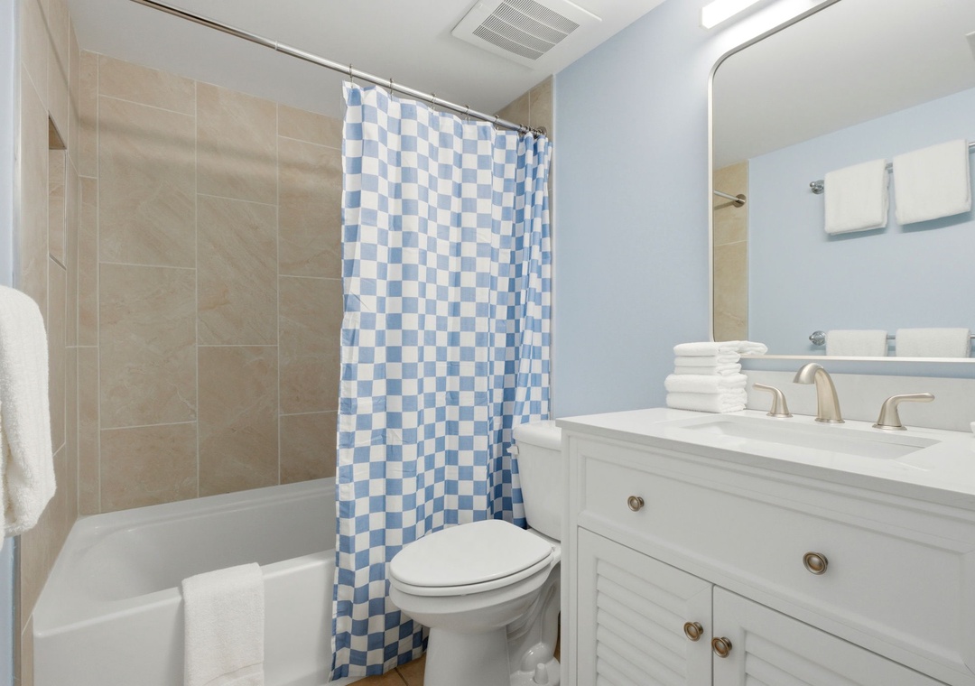 Sandy Key 637- Fresh linens and a cheerful checkered curtain welcome you to your private bathroom retreat. Sink into relaxation with clean surfaces, fluffy towels, and a bright coastal palette that makes every refresh feel special.