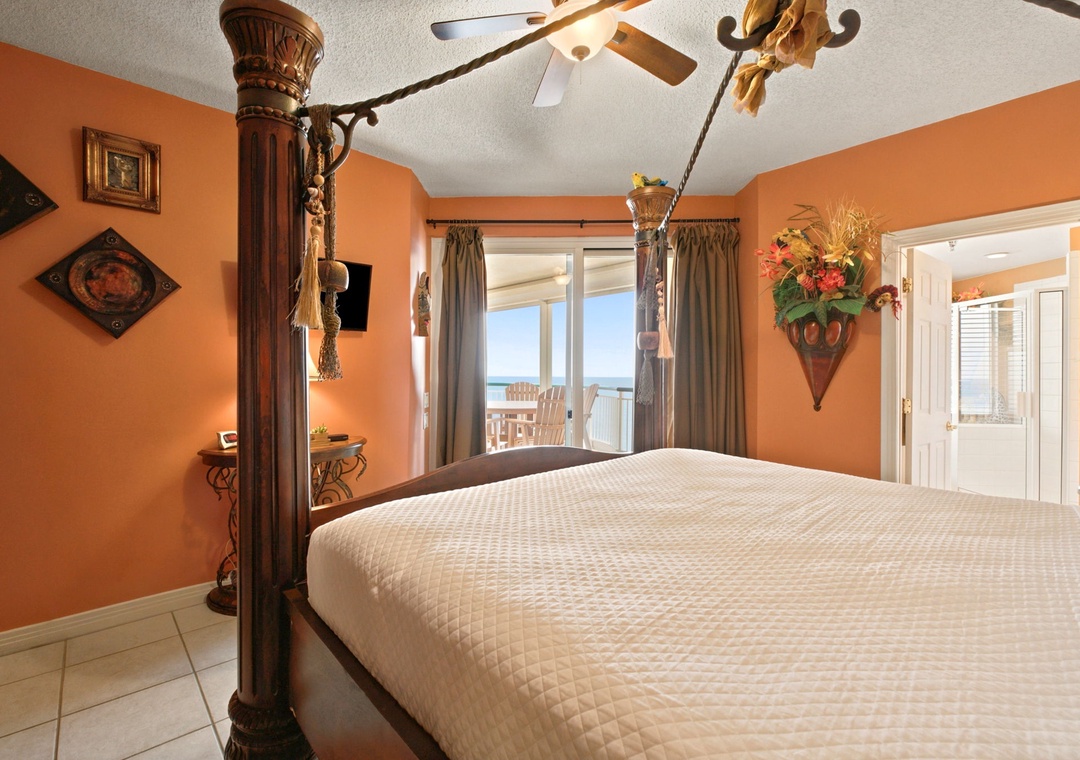 Beach Colony W13A- Wake up in this unique, warmly-lit bedroom with an ornate four-poster bed and ocean views through the balcony doors—a cozy tropical retreat designed just for you.