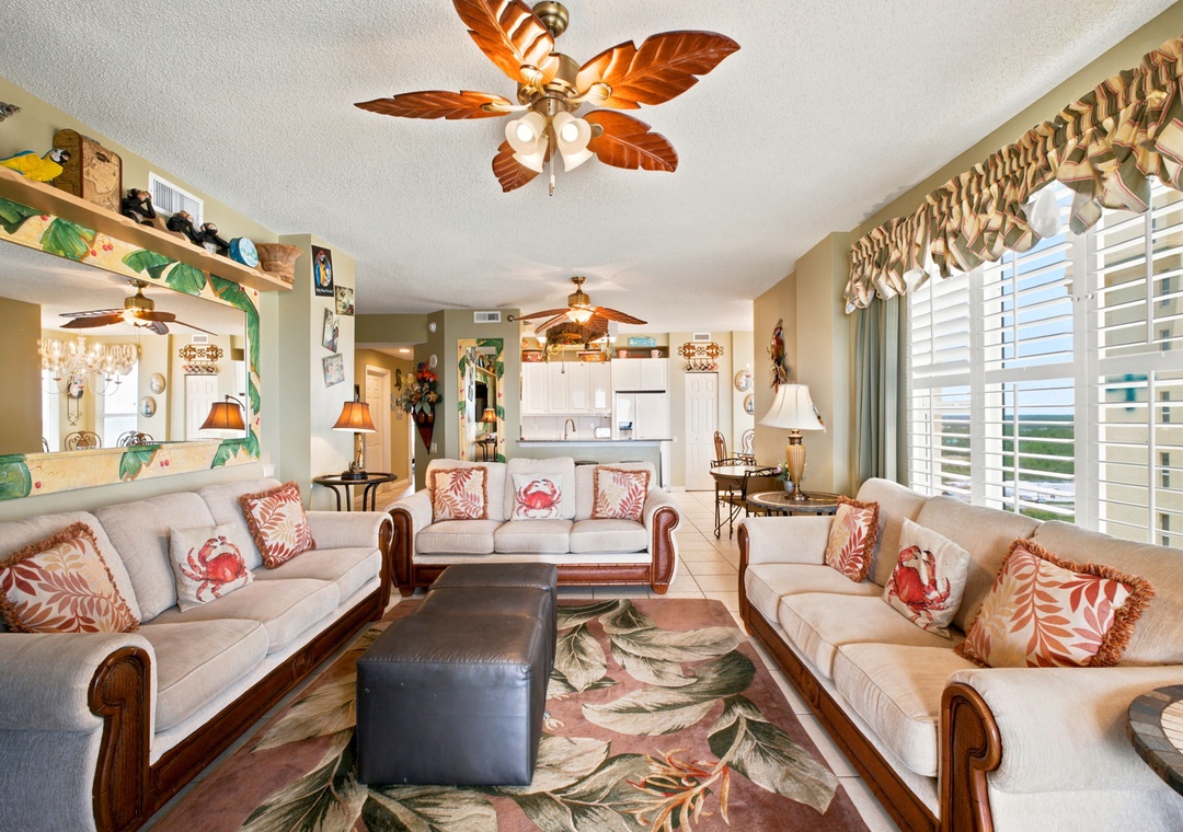 Beach Colony W13A-Settle into your inviting living space with tropical ceiling fans, coastal décor, and abundant natural light flowing through plantation shutters. The open layout connects you to the dining and kitchen areas, perfect for relaxing together