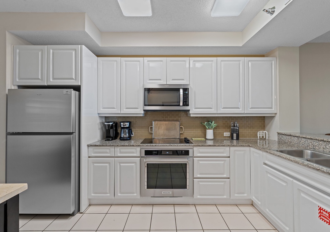 Beach Colony T15B- Your fully equipped kitchen has everything you need to prepare delicious meals. Crisp white cabinetry, stainless steel appliances, and ample counter space create a bright, functional cooking area.