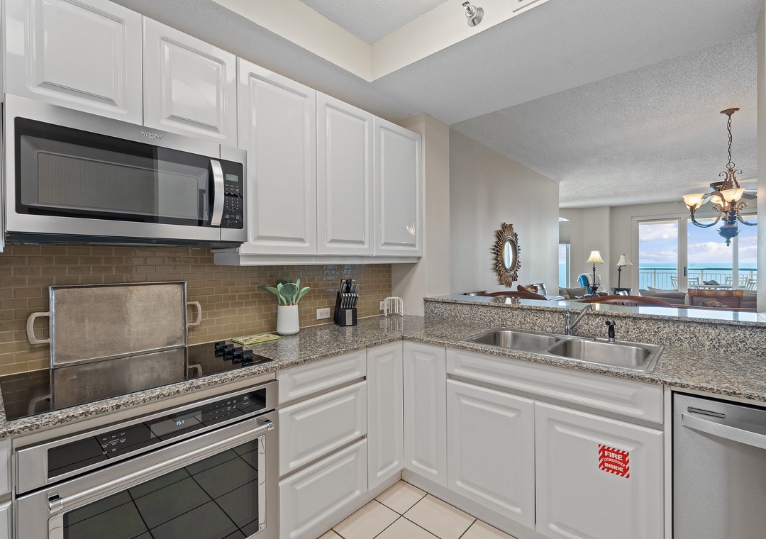Beach Colony T15B- Your fully equipped kitchen awaits with everything you need to prepare meals—granite counters, stainless appliances, and an open view into the living area where that sparkling ocean view beckons.