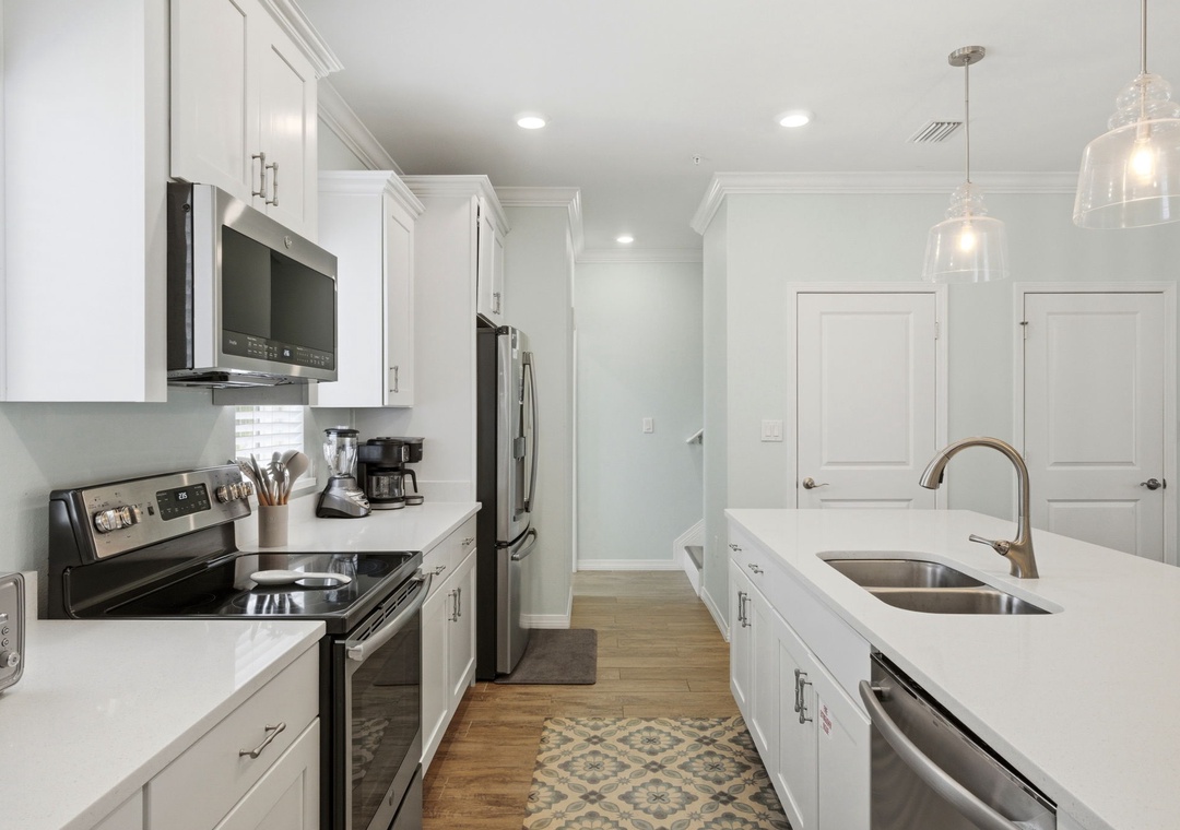 Step into your fully equipped kitchen with gleaming white cabinetry, stainless appliances, and plenty of counter space to prepare your favorite meals during your stay.