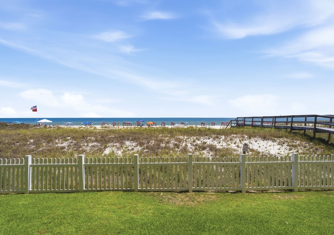 Ocean Breeze W 105- Sandy beach access just steps away, with a wooden boardwalk leading directly to the shore where umbrellas dot the coastline.