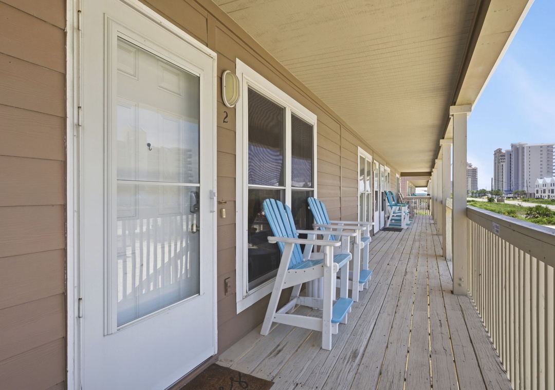 North Lost Key Landing B2- A spacious wooden deck positioned outside the property entrance, with the surrounding neighborhood and nearby buildings visible in the distance.