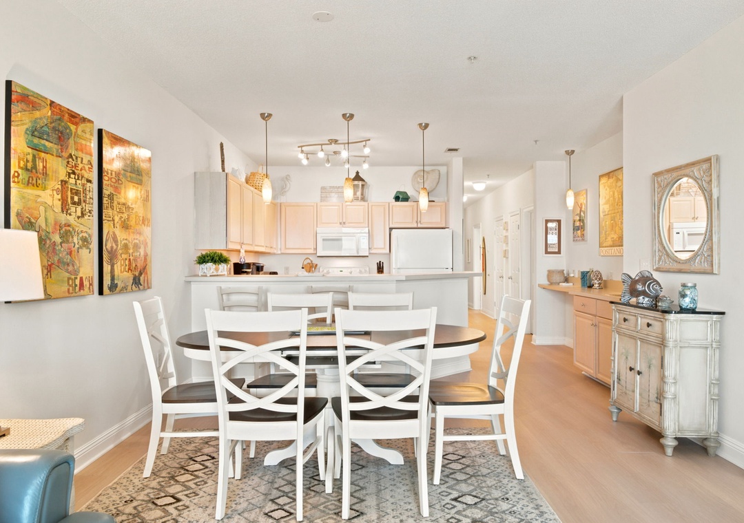 Step into your bright, open-concept living space where artful touches and warm wood finishes create an inviting atmosphere. Gather around the spacious dining table for meals together, while the well-appointed kitchen stands ready for your culinary adventu
