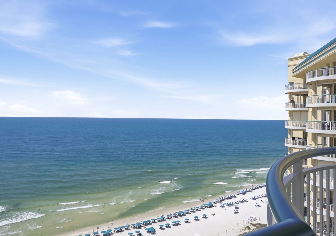 Beach Colony T PH1D- Breathtaking oceanfront view with pristine sandy beach below and azure waters stretching to the horizon. The curved balcony railing frames this stunning coastal panorama perfectly.