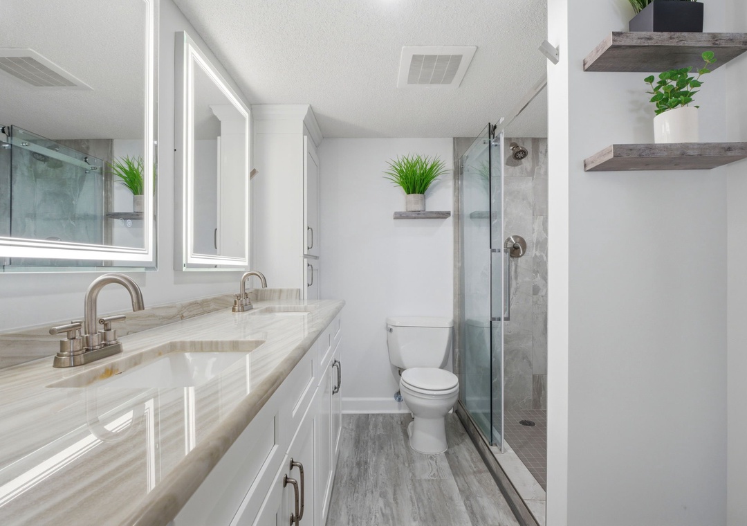 Step into your pristine ensuite with dual sinks, a spacious walk-in shower, and elegant touches like floating shelves and soft lighting that make getting ready each morning feel effortless.