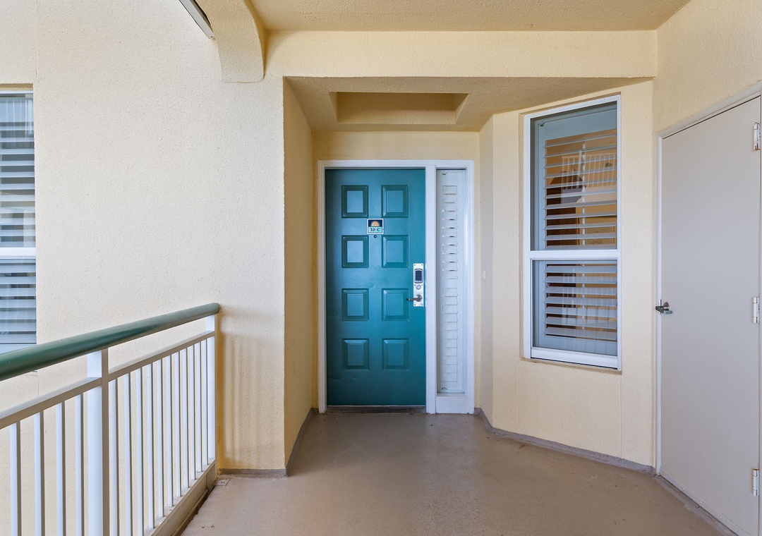 Beach Colony Tower 10C- Your private entrance awaits with its cheerful teal door, welcoming you into your own secure space with modern keypad entry for convenient arrivals.