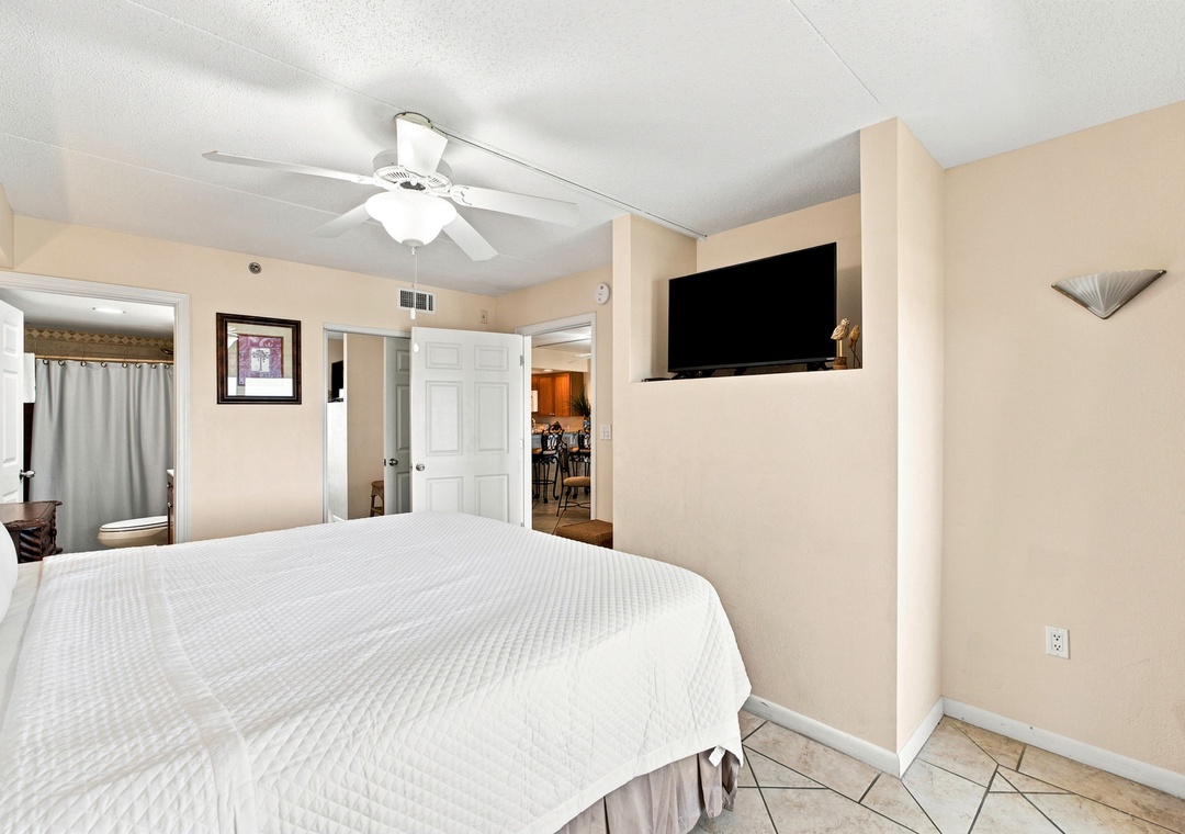 Relax in your comfortable bedroom with ceiling fan and flat-screen TV, where soft neutral tones and an open layout create a peaceful retreat for unwinding after a day of adventure.