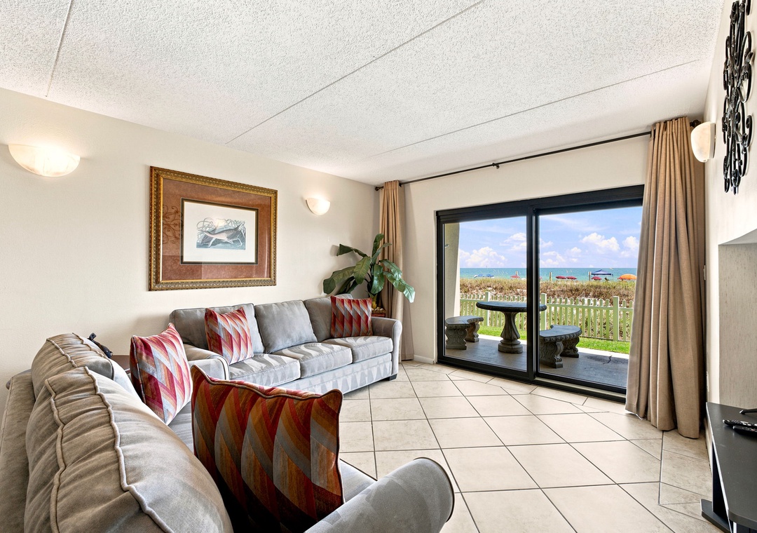 Ocean Breeze W 105-Unwind in your comfortable living space where soft seating invites you to relax and the ocean views through sliding glass doors promise peaceful coastal moments just beyond.