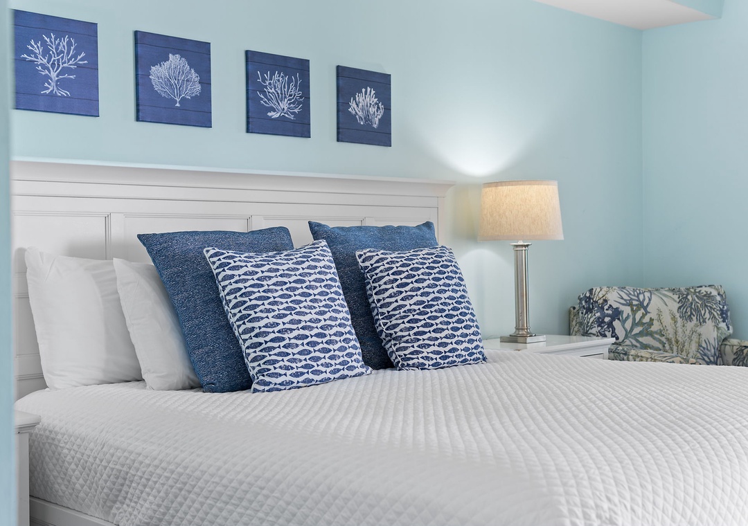 Beach Colony Tower 10C- Sink into crisp linens and coastal charm in your serene bedroom, where soft blues and nautical touches invite restful nights by the sea.