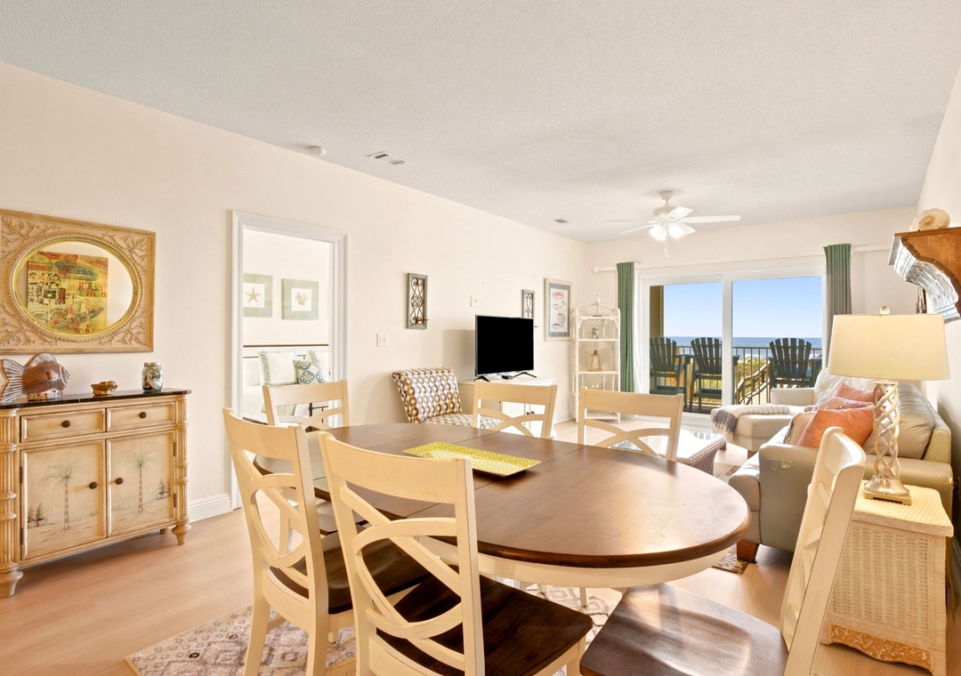 Relax in your bright, coastal-inspired living space with an open dining area and calming ocean views framed by sliding doors, inviting you to step outside and breathe in the sea breeze.